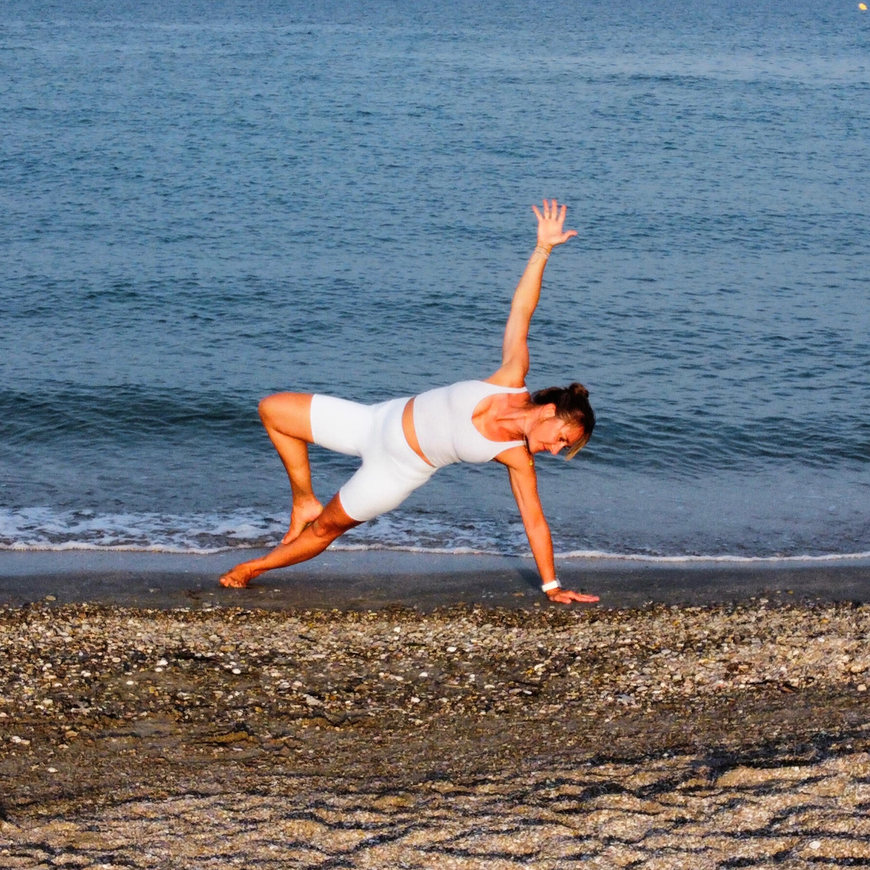 Nina Stutz in einer Balance-Pose am Strand – Yogastunden und Preise im Tanzlade Wohlen